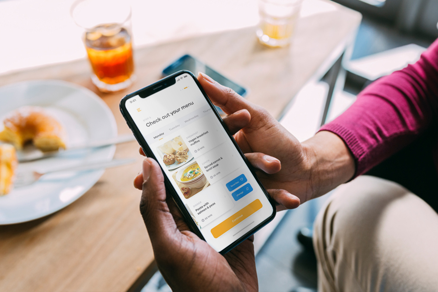 person sitting at table holding iPhone with Foodrush app on the screen
